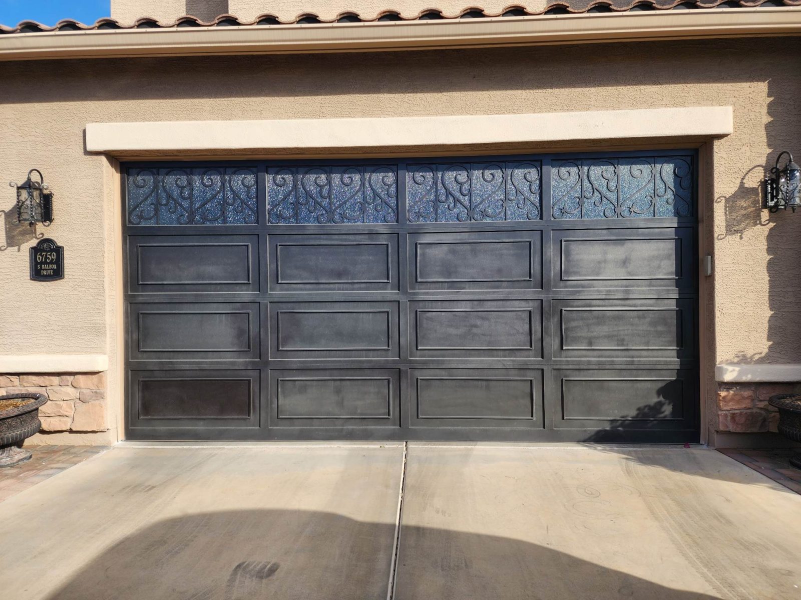 Dark bronze raised panel garage door with decorative scroll window inserts