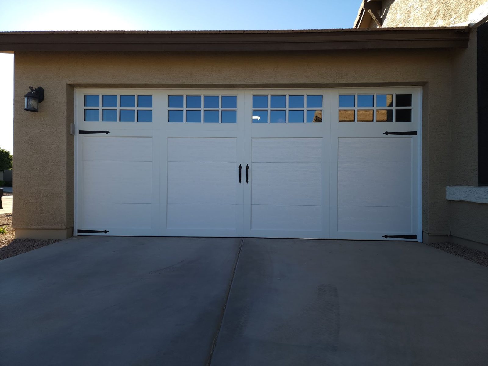 White carriage house garage door with windows and decorative hardware