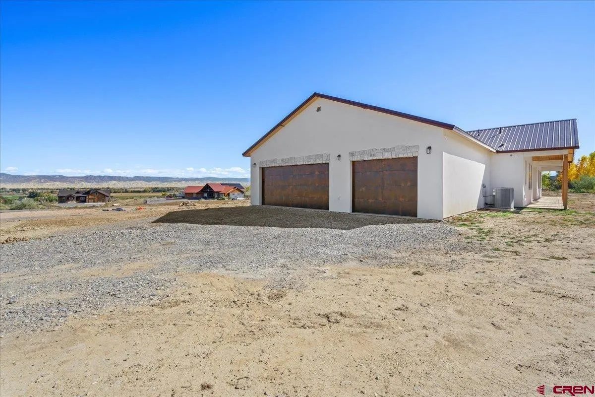 Two rust stained carriage house garage doors on a desert workshop with a metal roof